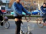 男人穿高筒靴骑折叠小单车